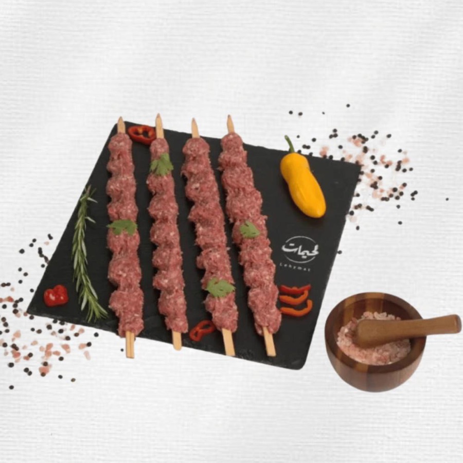 أربعة أسياخ كباب غنم نعيمي طازج على لوح إردواز أسود مع فلفل وملح